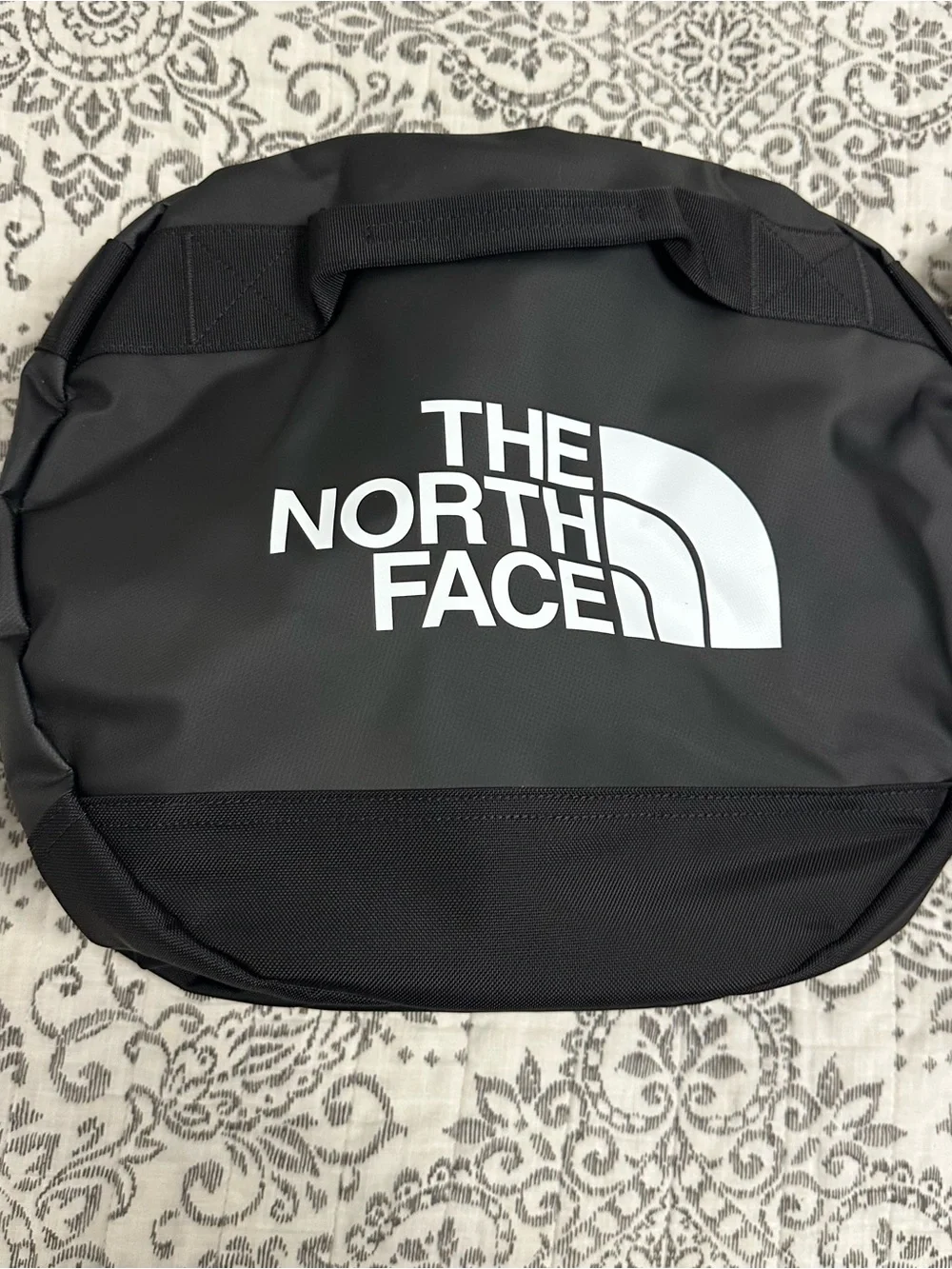 The North Face Base Camp Duffel M in Black with Red Tag